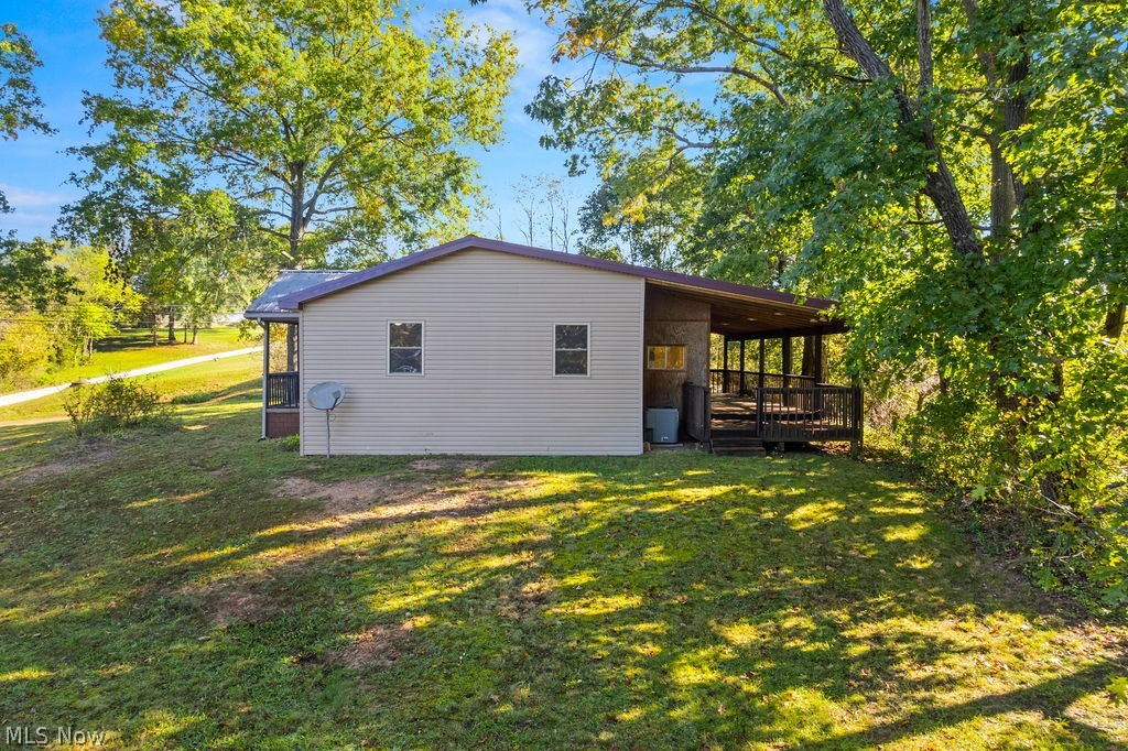 58 Rock Ridge Road Mineral Wells, WV 26150 - Photo 25 of 38 Exterior siding with multiple windows, covered porch, and mature trees surrounding the property