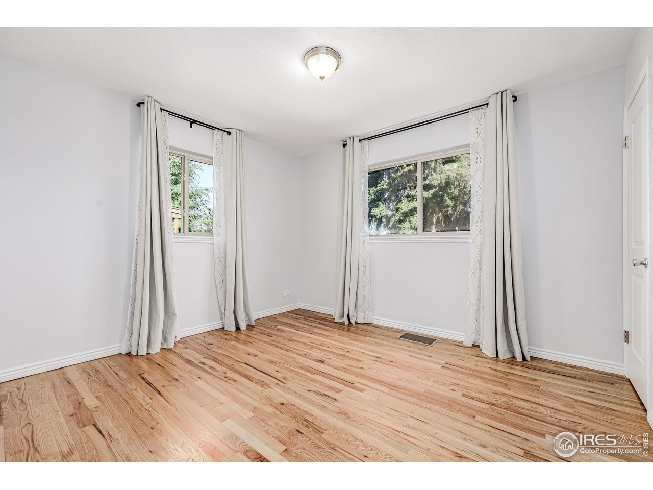 2675 Pontiac Street Denver, CO 80207 - Photo 16 of 50 a view of an empty room with wooden floor and a window