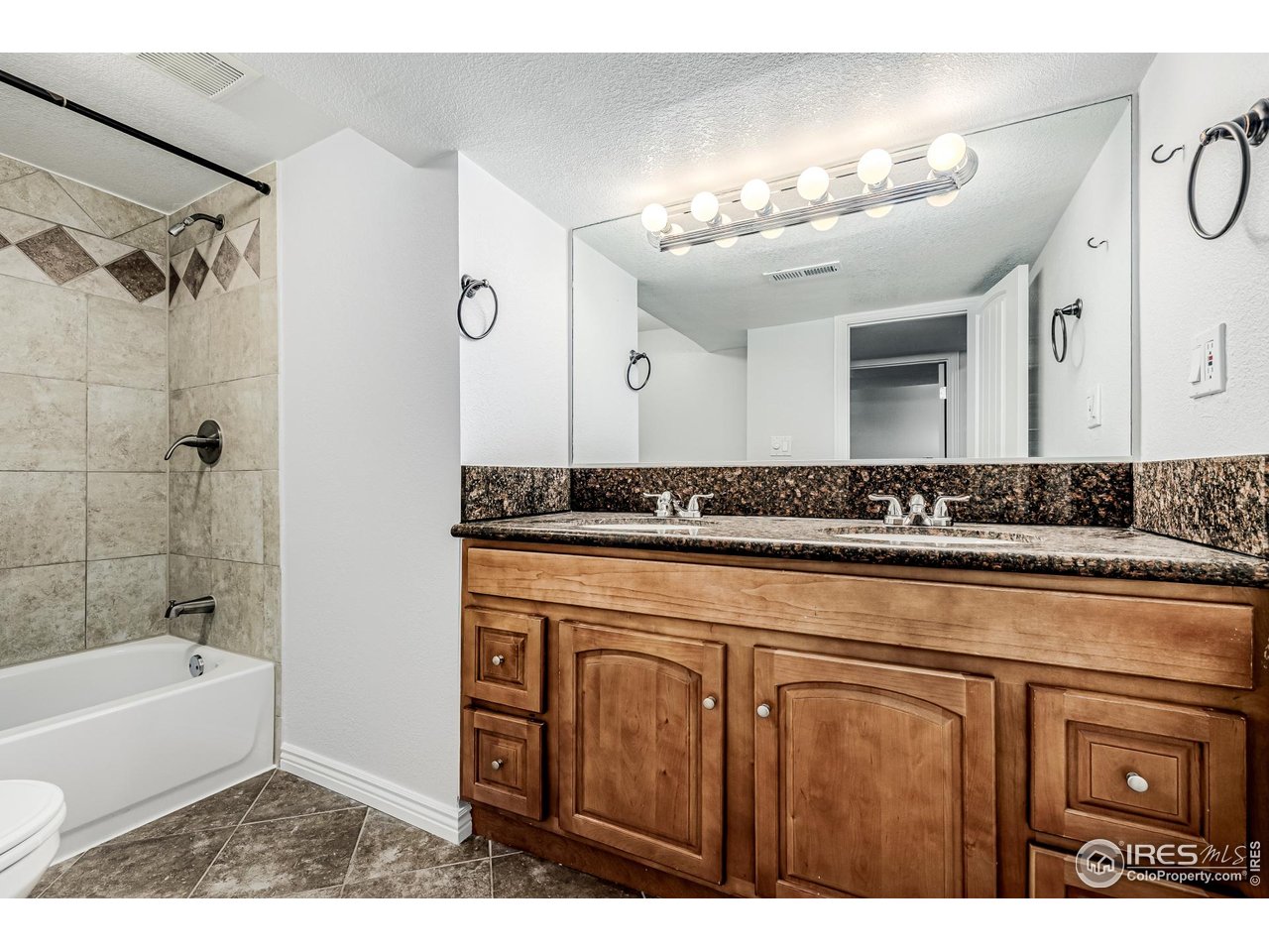 2675 Pontiac Street Denver, CO 80207 - Photo 22 of 50 a bathroom with a sink a mirror and a bathtub