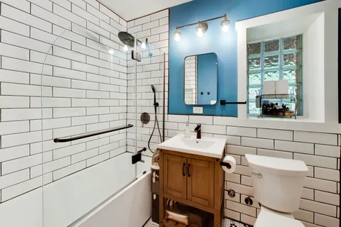 a bathroom with a sink mirror vanity and toilet