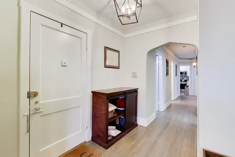 a view of a hallway with wooden floor and staircase