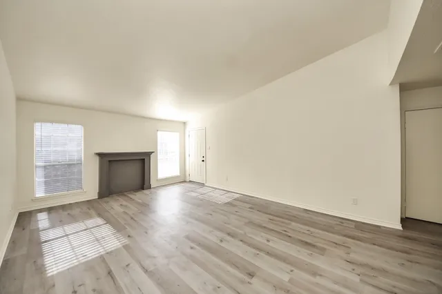 an empty room with wooden floor and mirror