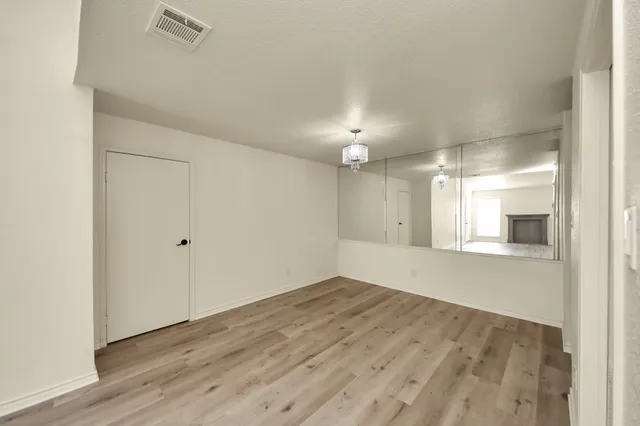 an empty room with wooden floor and fireplace
