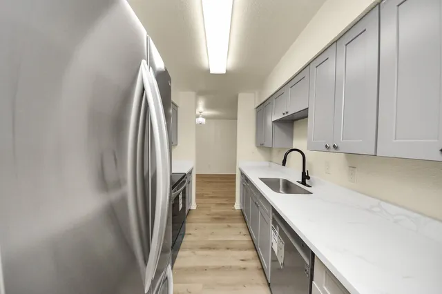 a kitchen with a sink and stainless steel appliances
