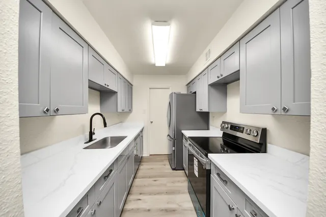 a kitchen with a sink a stove and refrigerator