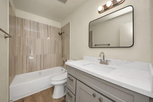 a bathroom with a toilet sink and mirror