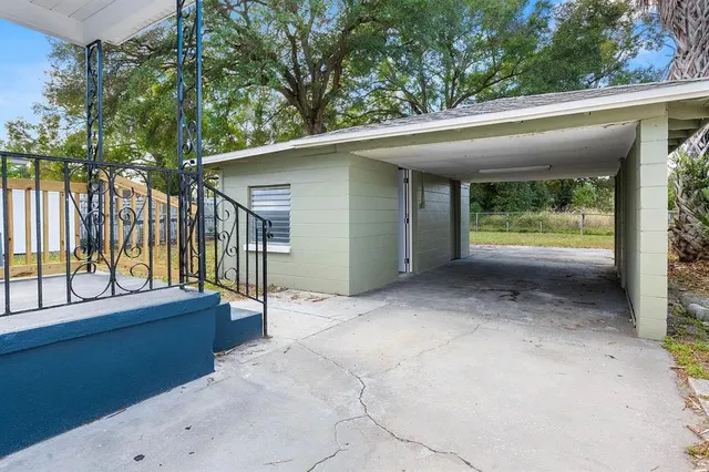 a view of backyard with large trees and plants