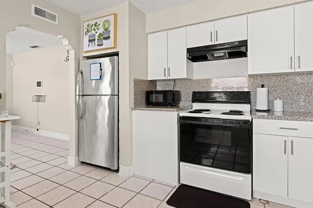 a kitchen with stainless steel appliances a refrigerator sink and cabinets