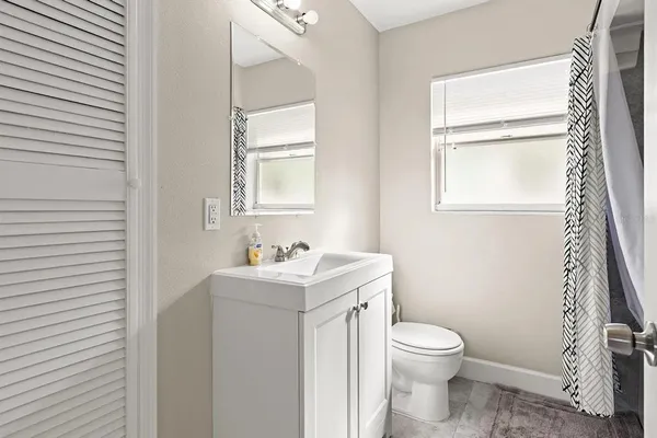 a bathroom with a toilet a sink a vanity and mirror