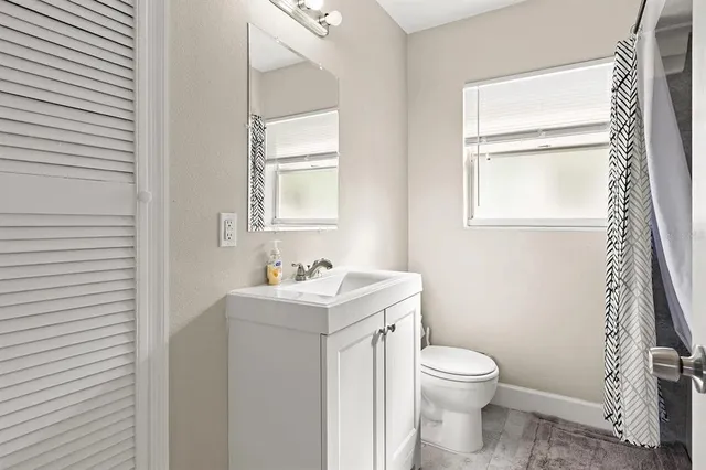 a bathroom with a toilet a sink a vanity and mirror