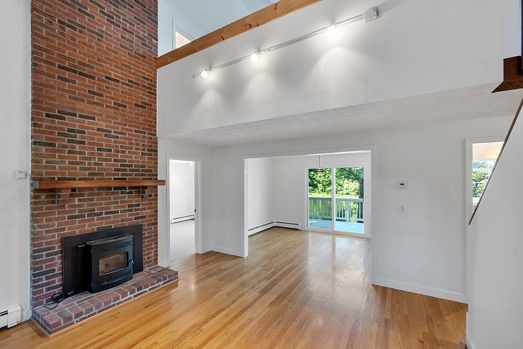 71 Mill Road Littleton, MA 01460 - Photo 2 of 30 a view of a livingroom with wooden floor and a fireplace