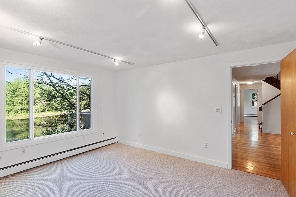 71 Mill Road Littleton, MA 01460 - Photo 8 of 30 an empty room with wooden floor and windows