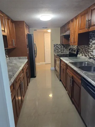 a kitchen with stainless steel appliances granite countertop a sink stove and cabinets