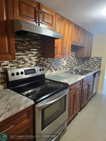 a kitchen with granite countertop a stove and a sink