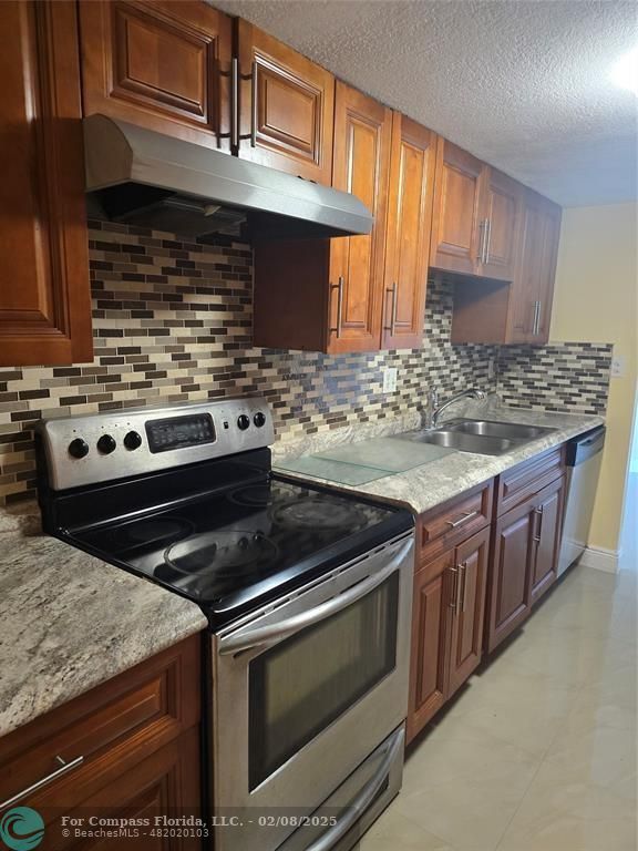 7051 Environ Boulevard, Unit 336 Lauderhill, FL 33319 - Photo 4 of 15 a kitchen with granite countertop a stove and a sink