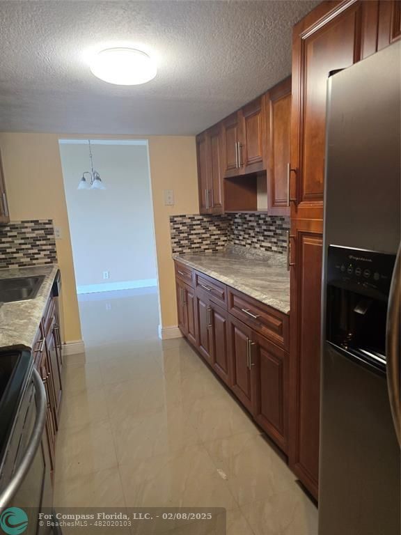 7051 Environ Boulevard, Unit 336 Lauderhill, FL 33319 - Photo 5 of 15 a kitchen with stainless steel appliances granite countertop a stove a refrigerator and a oven