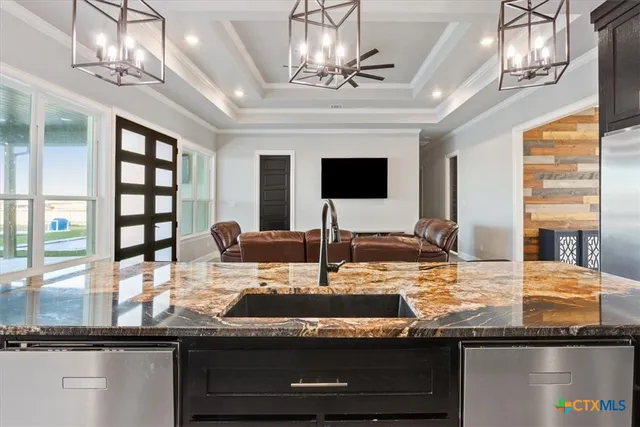 a view of a dining room with furniture a chandelier and large windows