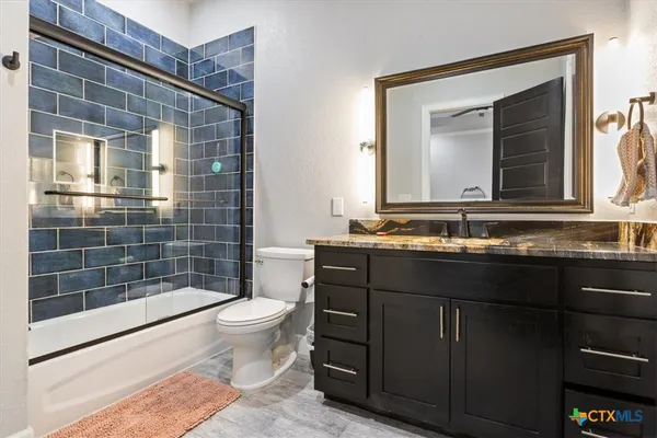 a bathroom with a sink a toilet a mirror and shower