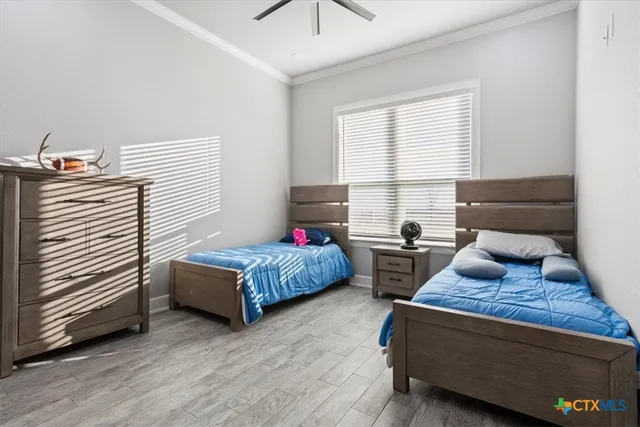 a bedroom with two beds and wooden floor