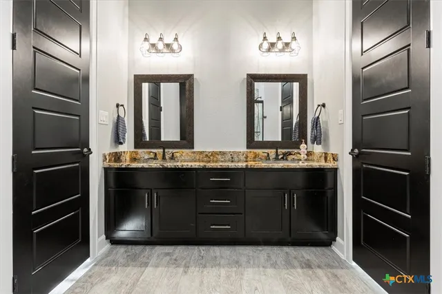 a bathroom with a double vanity sink and a mirror