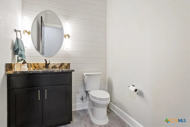 a bathroom with a toilet a sink and mirror