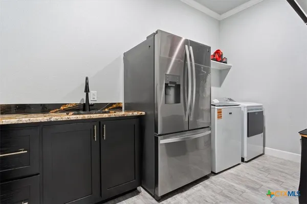 a kitchen with granite countertop a refrigerator and a sink