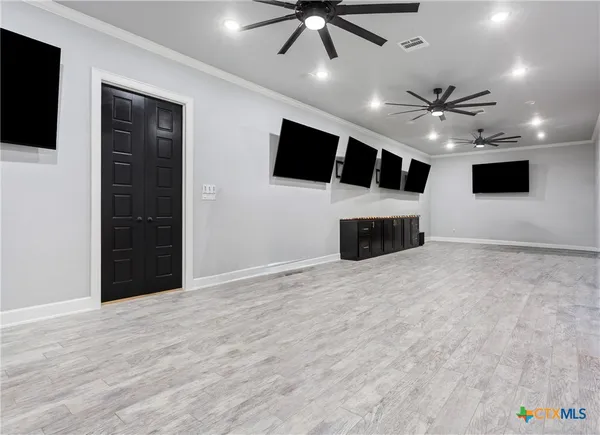 a big room with windows fireplace and a chandelier fan