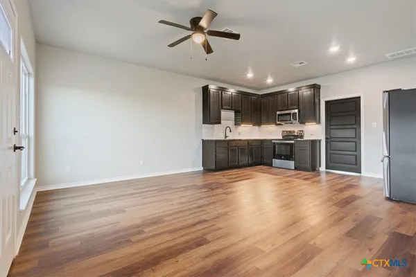 a view of kitchen with sink microwave and refrigerator