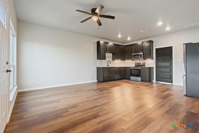 a view of kitchen with sink microwave and refrigerator