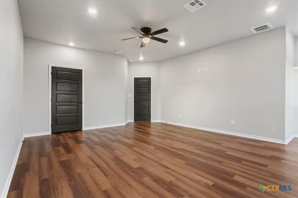 a view of an empty room with wooden floor