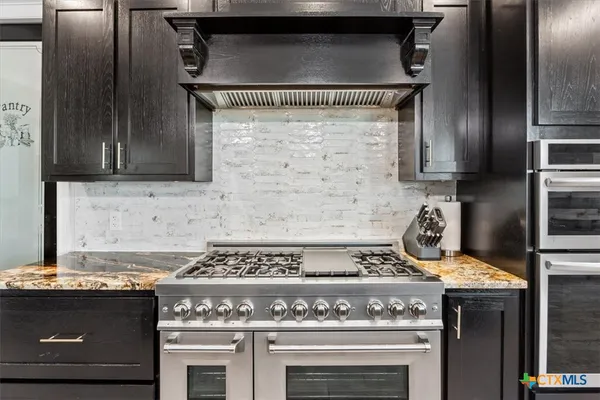 a stove top oven sitting inside of a kitchen