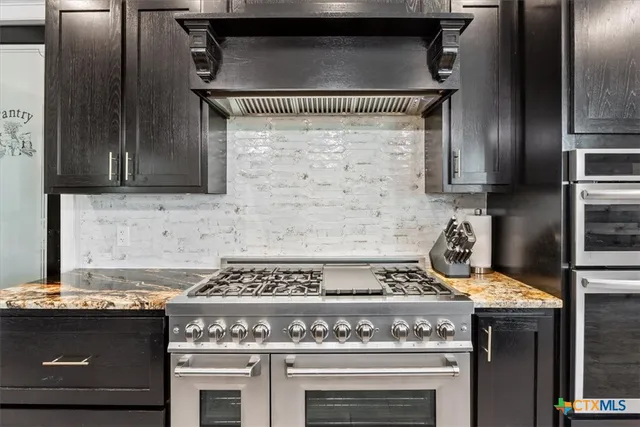 a stove top oven sitting inside of a kitchen