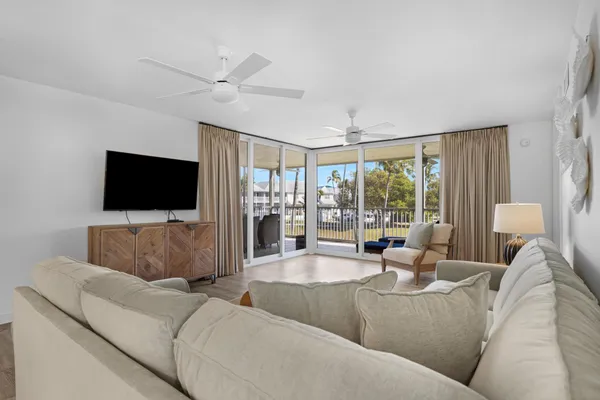 a kitchen with stainless steel appliances a sink dishwasher a stove top oven a refrigerator with grey cabinets and wooden floor