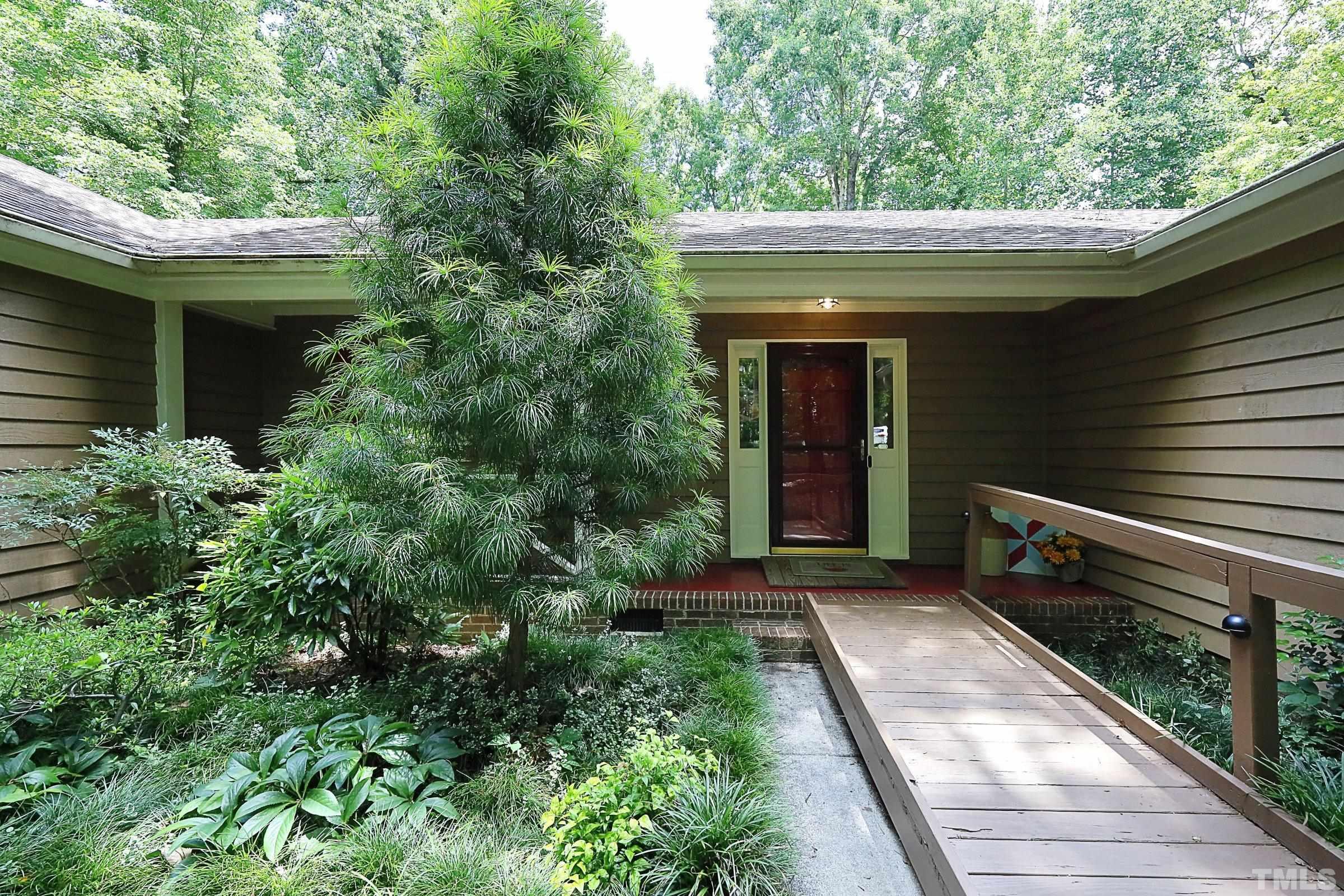 11468 Claybank Place Raleigh, NC 27613 - Photo 4 of 34 a view of backyard with potted plants and a large tree