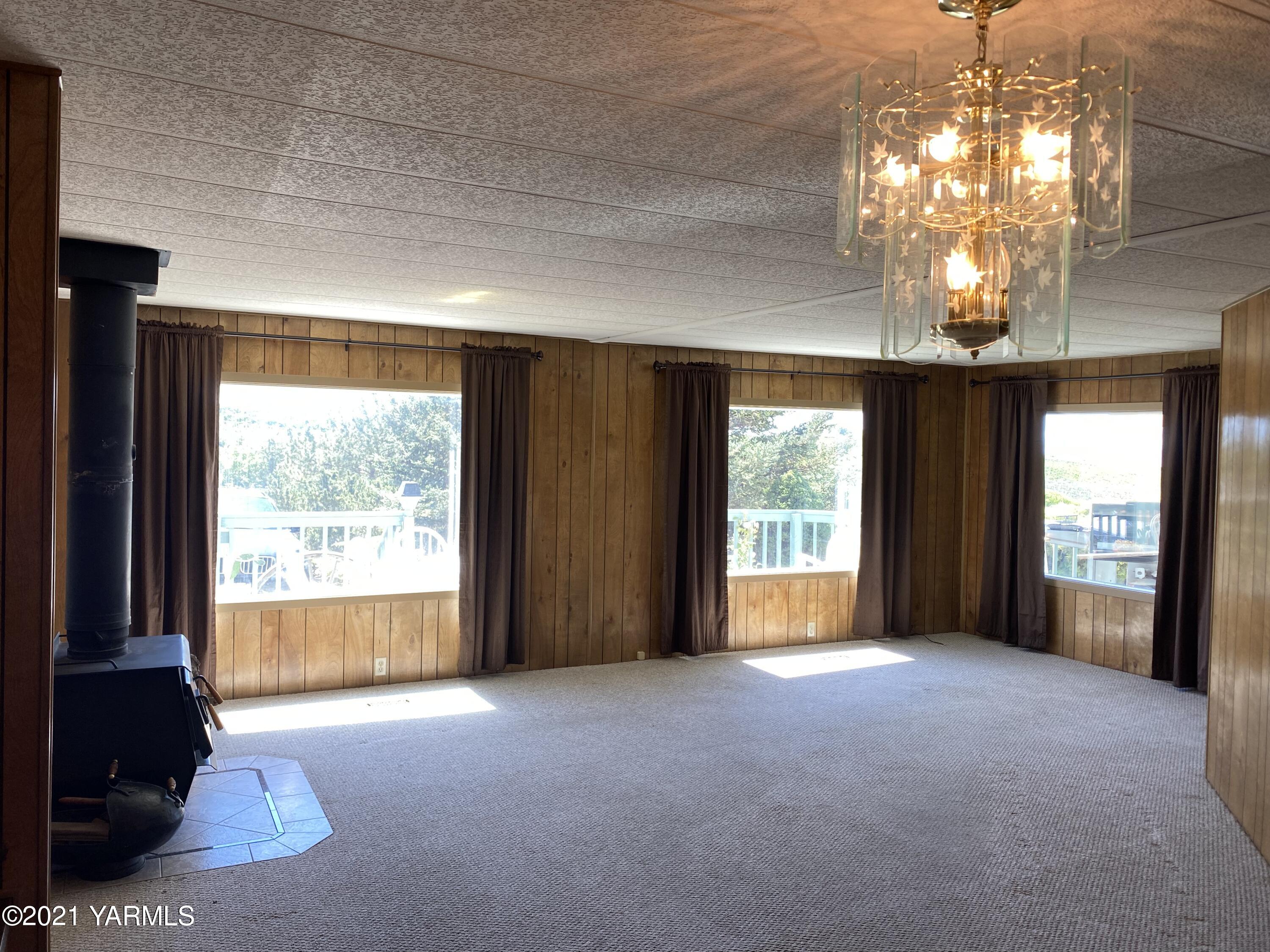 363 Riggins Road Wapato, WA 98951 - Photo 2 of 14 a view of a livingroom with a chandelier curtains and large windows