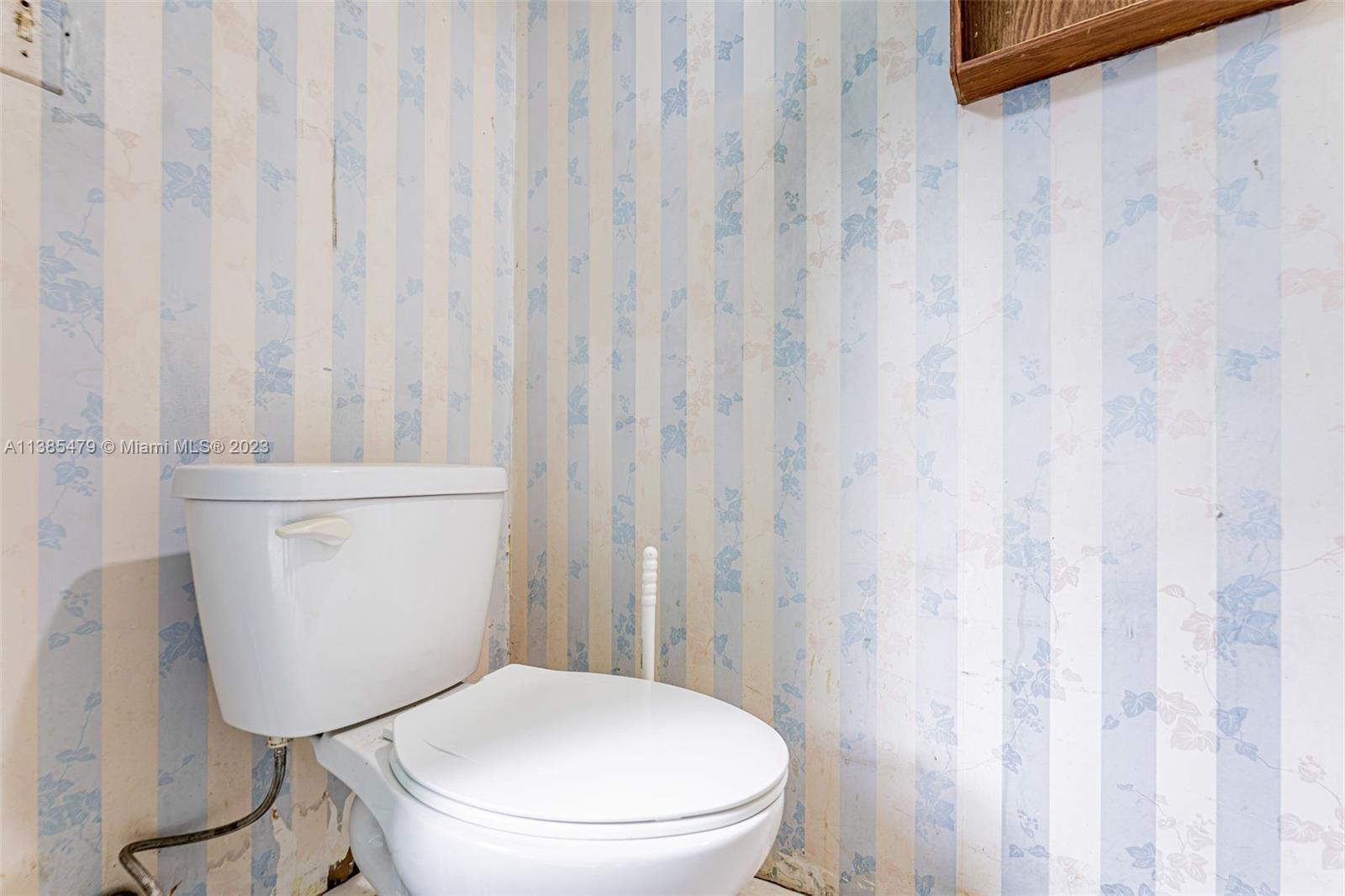 8241 Southwest 37th Street Miami, FL 33155 - Photo 32 of 46 a white toilet sitting next to a shower curtain