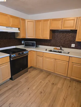 a kitchen with a sink stove and cabinets