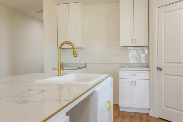 a kitchen with a refrigerator and white cabinets