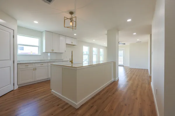 a kitchen with white cabinets appliances and a window