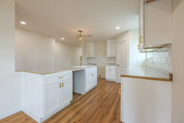 a kitchen with sink a microwave and cabinets