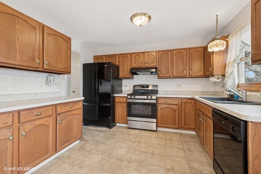 544 Arthur Drive Cary, IL 60013 - Photo 5 of 23 a kitchen with stainless steel appliances granite countertop a refrigerator stove and sink