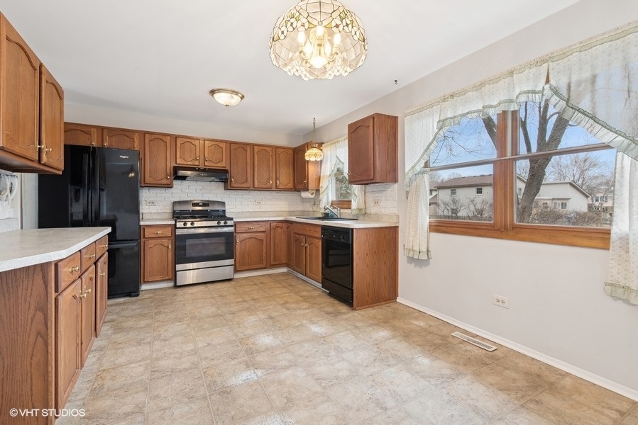 544 Arthur Drive Cary, IL 60013 - Photo 8 of 23 a kitchen with stainless steel appliances granite countertop a stove top oven