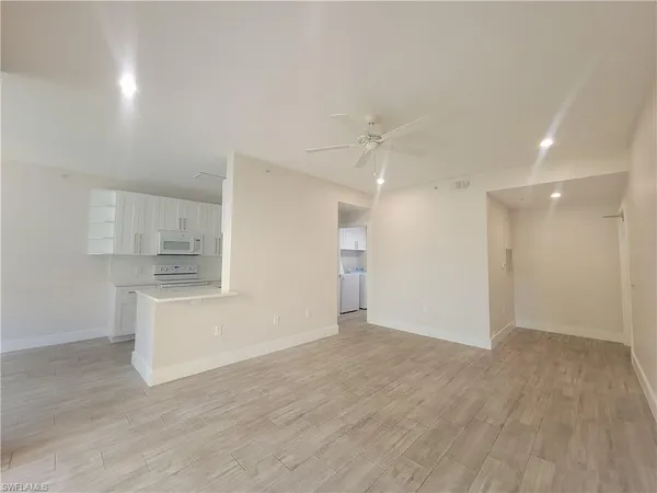 a view of kitchen with wooden floor and electronic appliances
