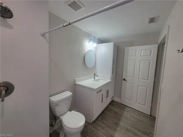 a bathroom with a toilet a sink and mirror