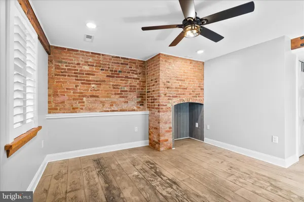an empty room with a white cabinet and a ceiling fan