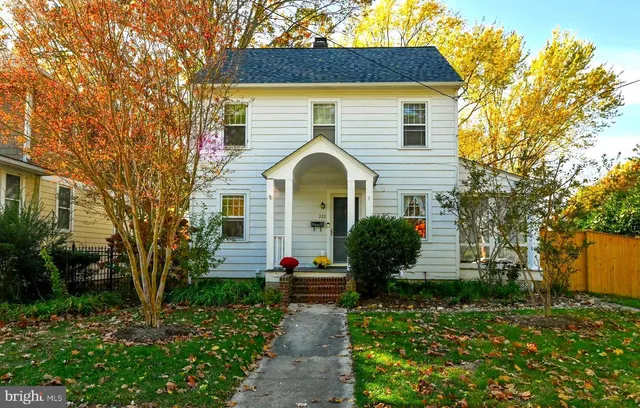 a front view of a house with a yard and trees