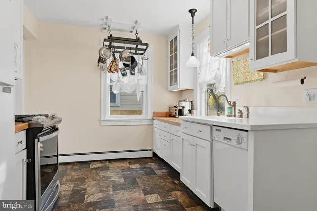 a kitchen with a sink refrigerator and window