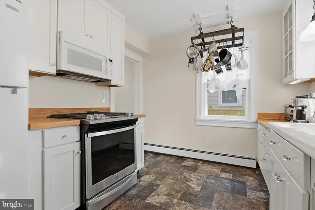 a kitchen with white cabinets and appliances