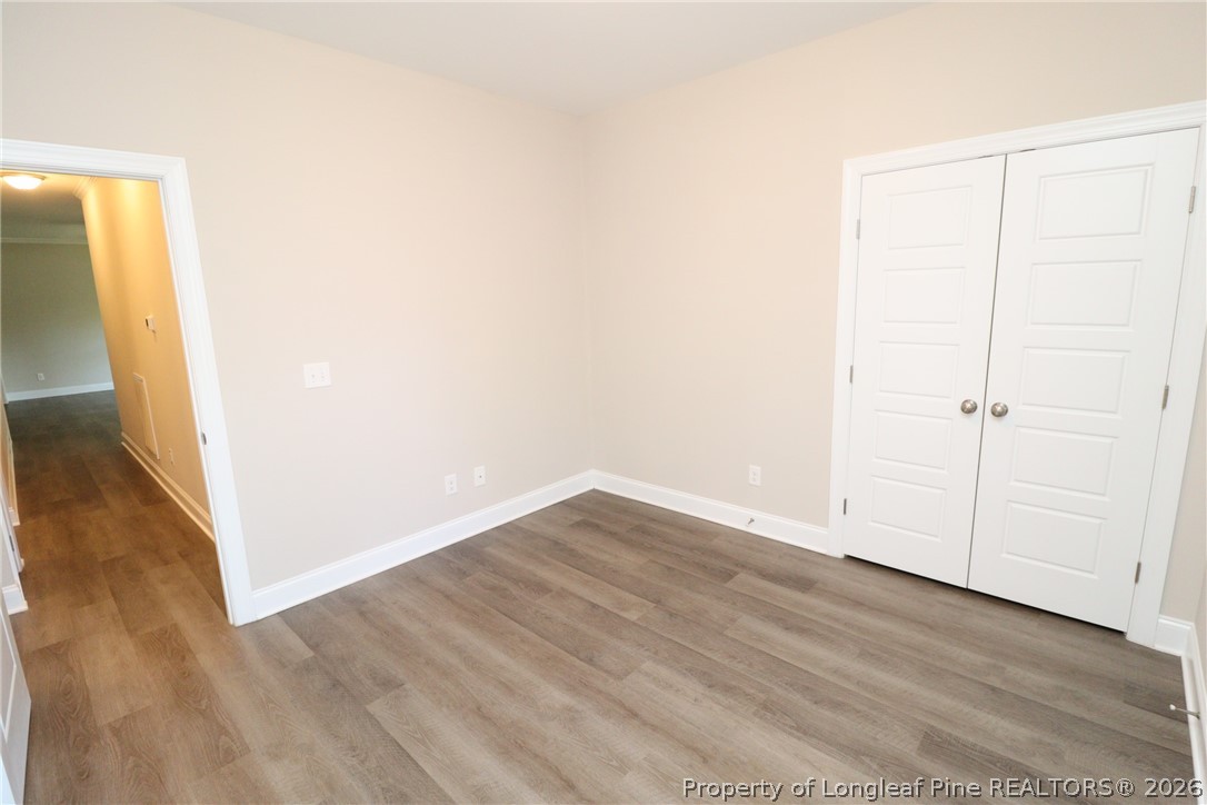 8424 Rhodes Road Apex, NC 27539 - Photo 24 of 31 a view of an empty room with wooden floor and a window