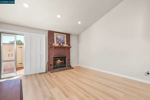 an empty room with a fireplace and cabinet